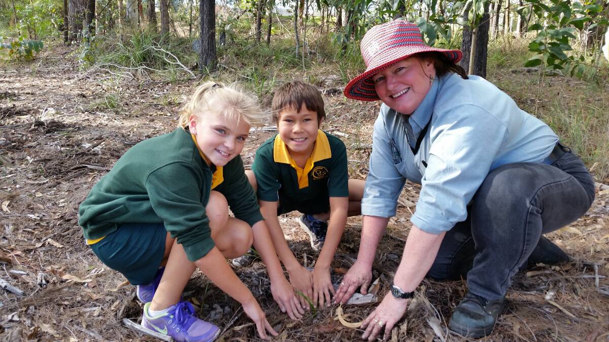Ella Hofmann and Jacob Tippo plant trees with Maree Manby from Indigiscapes. PHOTOS: Margie McNamara