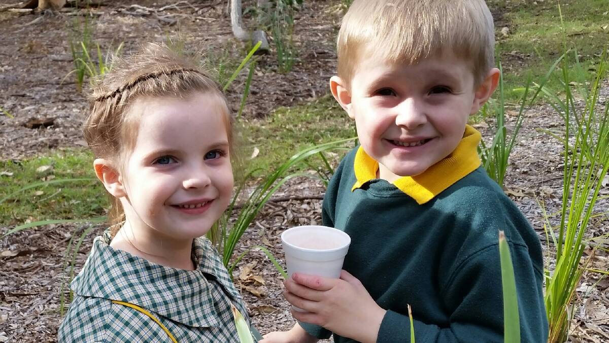 GREEN THUMBS: Cherry Borg and William Buckley enjoy a warm milo after planting. 