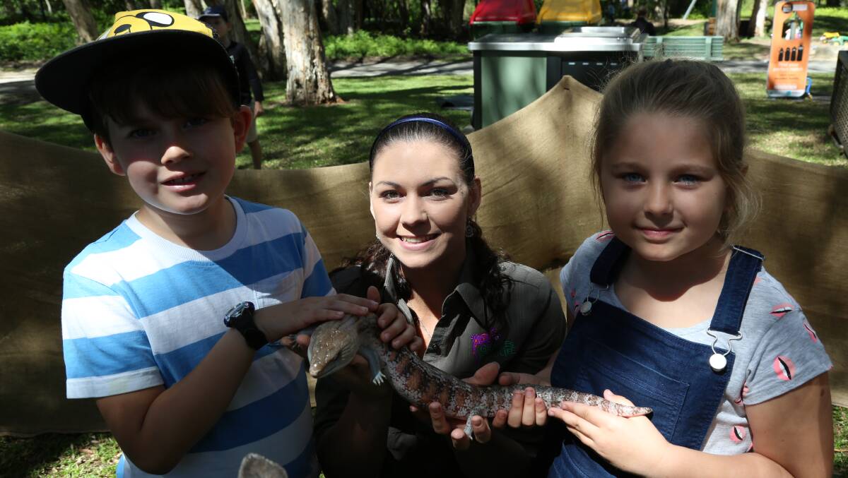 LIZARDS: Max Birkett, 6 and Chelsea Walko, 7, of Lota meet Naomi Harney of Gecko Wildlife and her friend at Indigiscapes.