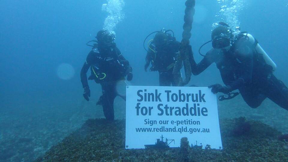 The Sink Tobruk for Straddie campaign even went underwater. Ricky Gillbert, Darren Smith and Doug Kuskopf-Dallas give Premier Annastacia Palaszczuk (and a few fish) the message.
