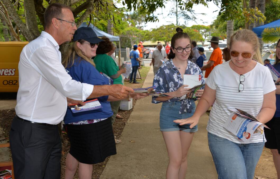 BUSY BOOTH: Voters make their way past candidate Peter Dowling and sister Sheena Hewlett on polling day at Victoria Point State School.