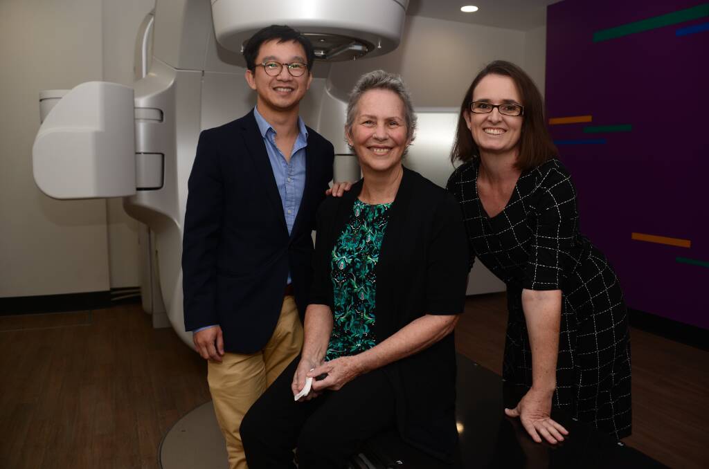 LOCAL TREATMENT: Dr Tuan Ha at the Varian TrueBeam linear accelerator, with patient Elizabeth Bass and centre manager Belinda Petherick.