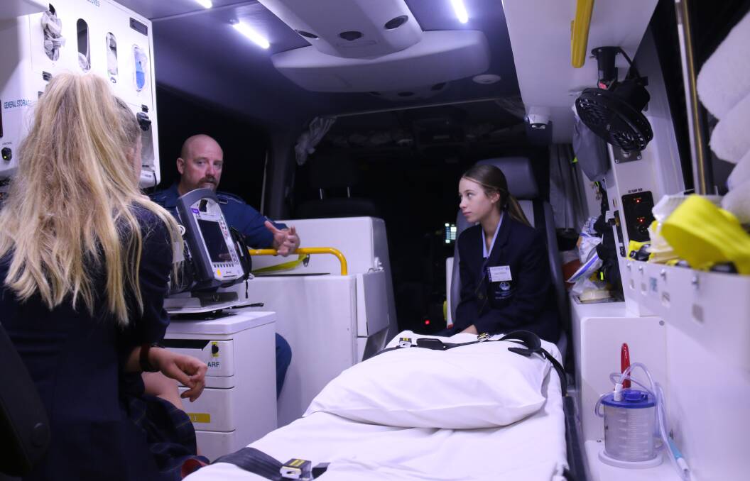 HANDS ON ADVICE: Paramedic Geoff Davies talks to student  Jessica Wilkins. The student with her back to the camera is Hayley Robinson. 