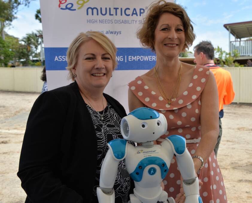 ROBOT HELP: Disability Services Minister Coralee O'Rourke and Multicap chief executive Joanne Jessop get a little help from a robot at the Alexandra Hills site.