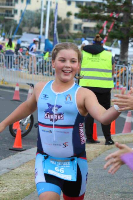 High five: Darcie Young accelerates out of transition at the Raby Bay Triathlon. Photos by John Warlters