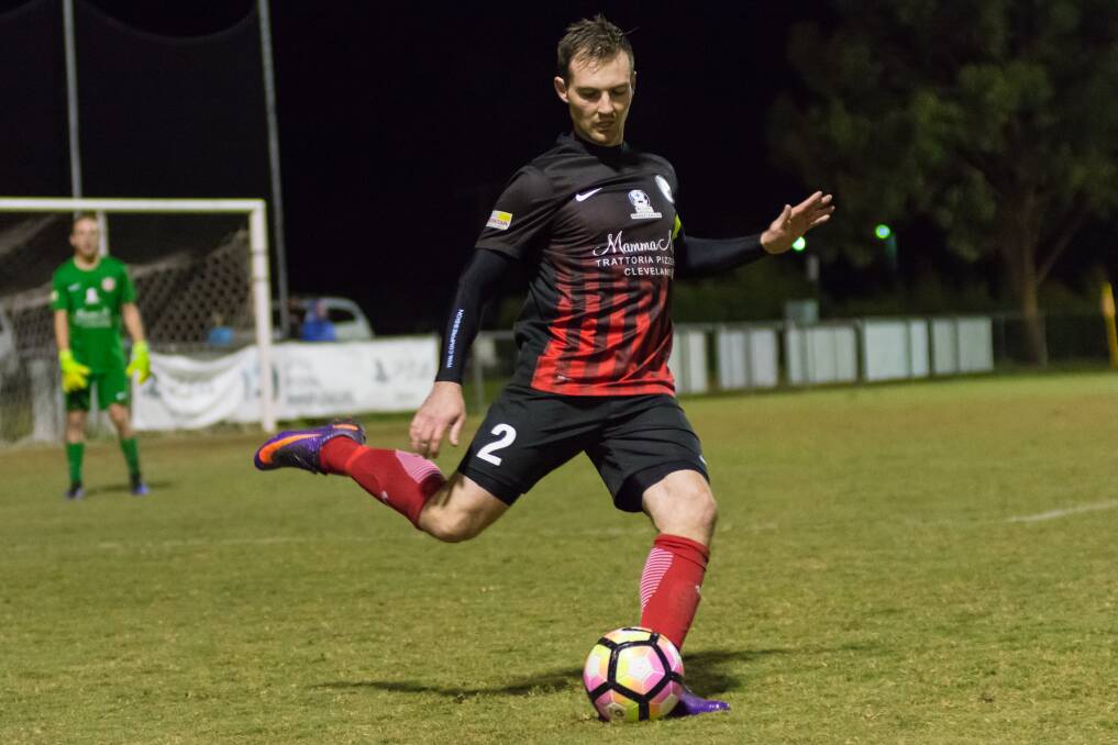 Skipper: Redlands captain Michael Ryan clears the ball during the Red Devils' 2-1 PS4 NPL win over FNQ Heat last Saturday evening. It was a heated affair, ending in a send-off. Photo: Andrew Hudson
