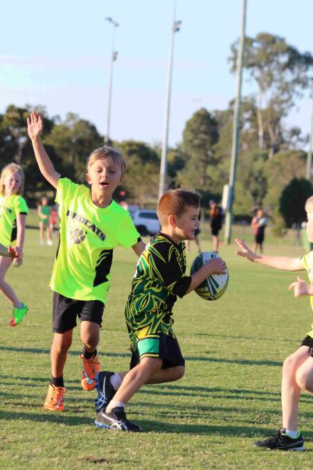 Attack: Jace O'Malley, Predators under 8s, takes on the Wildcats' defence. Photo: John Warlters