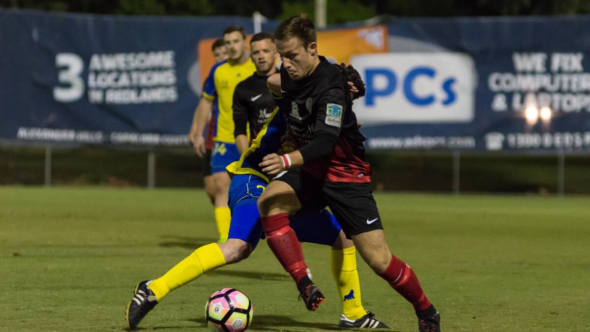 Redlands' Alex Warrilow goes past his man during the Red Devils' recent clash against the Brisbane Strikers. Photo by Andrew Hudson
