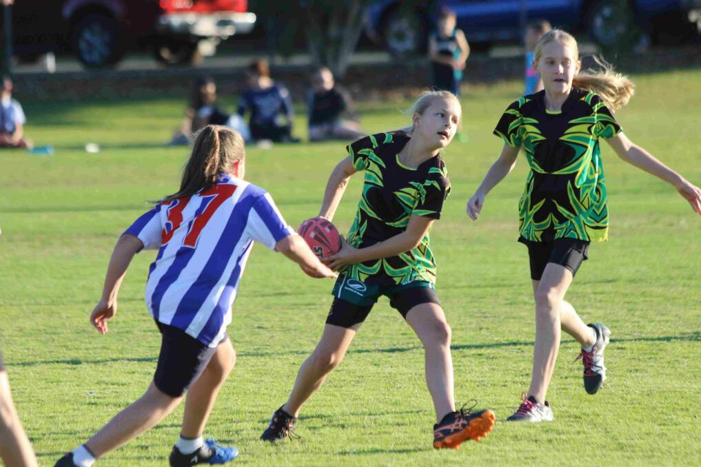 Pass: Jayda Little, Predator under 10s, looks outside for support during her Redlands Junior Touch match. Photo: John Warlters