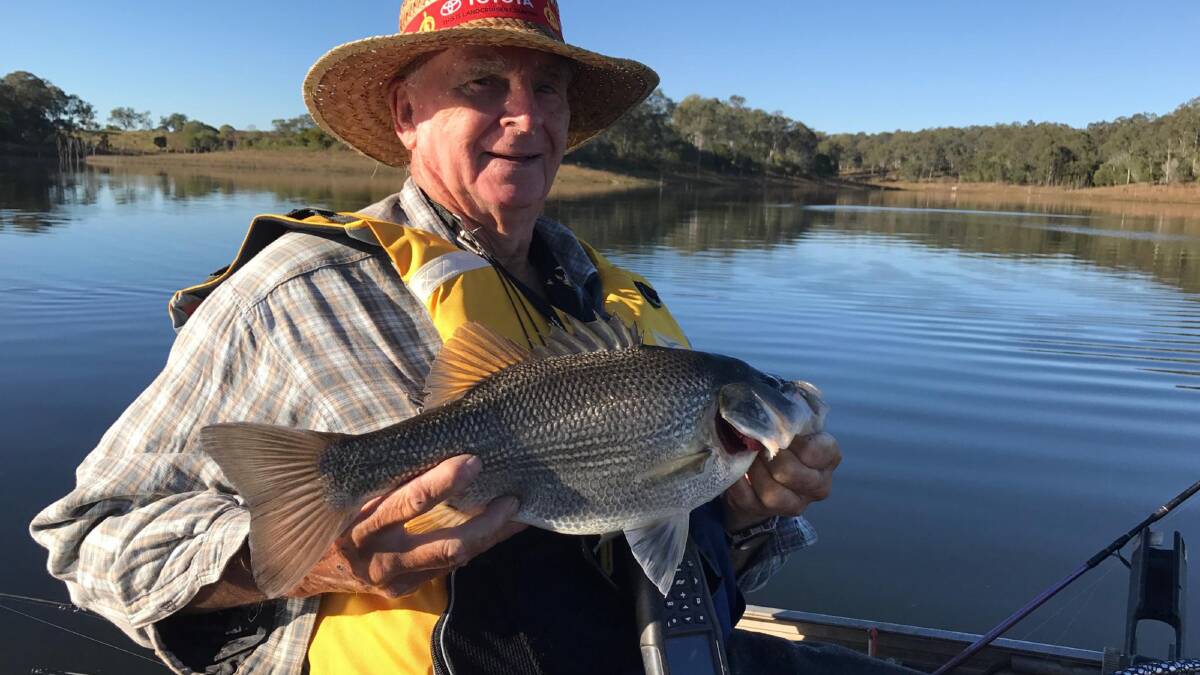 Caught him: Fisherman Ray Kennedy with a solid bass he managed to catch on a shrimp bait in North Pine Dam. Photo: Supplied