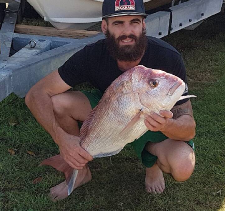 Decent sized catch: Luke Maloney with a 79cm snapper caught from the Moreton Bay shallows. Photo: Supplied