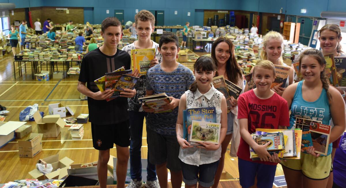 SORTING: Students from Cleveland District State High School and Calvary Christian College mission teams sort books donated for schools in Vanuatu.