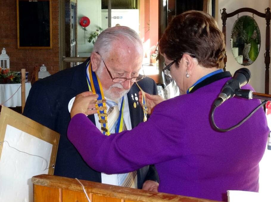 INDUCTION: President Janet Butler invests Reverend Allan Goodwin with the collar of office during his induction as president of the Rotary Club of Redland Sunrise. Photo: Supplied