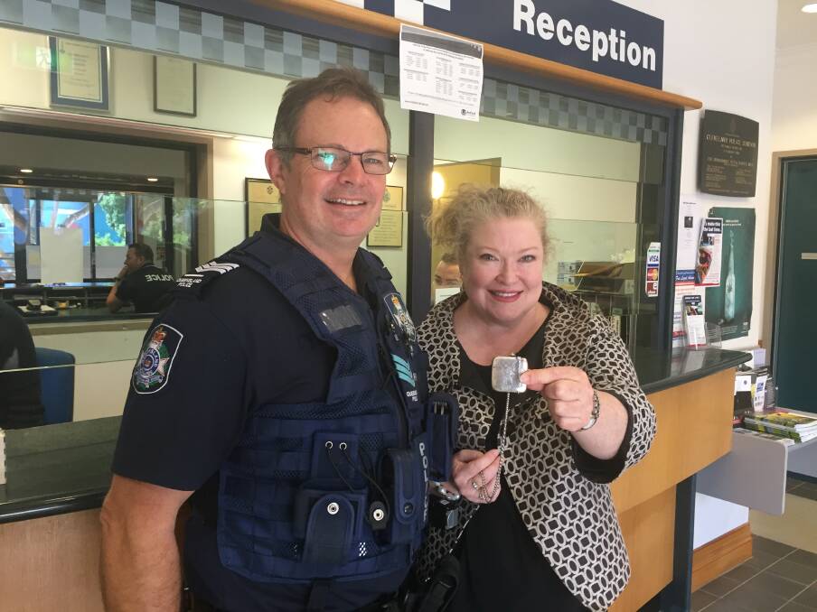 ALL SMILES: A relieved Samantha Keegan holds the antique match case she got back from Cleveland police station's Sergeant Mark Thomas after it was handed in. Photo: Cheryl Goodenough