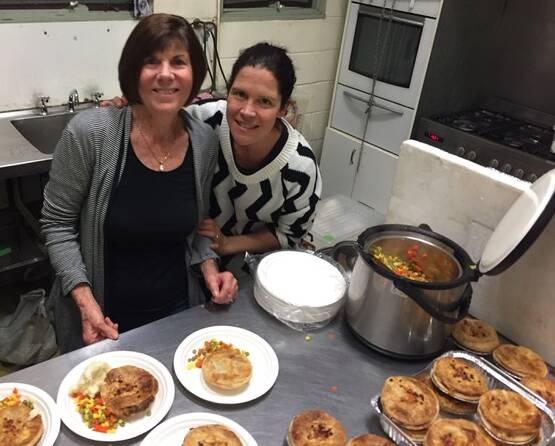 VOLUNTEERS: Catherine Stynes and Elizabeth Carty plate up pies donated by Crusty Edge bakery at Redland Bay. Photo: Supplied