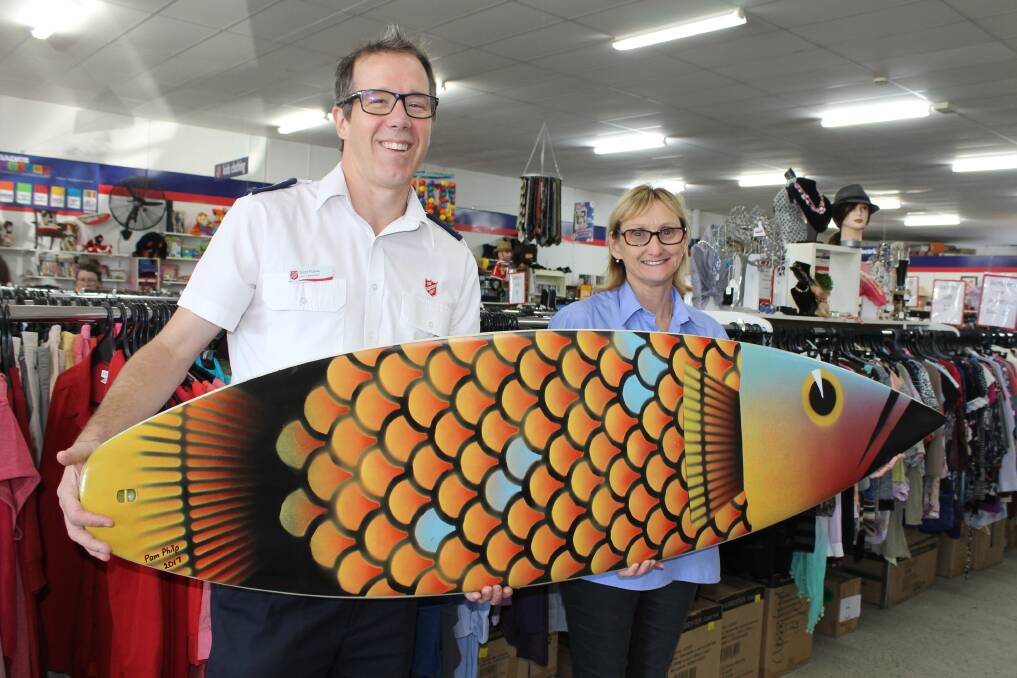 CALLING FOR SUPPORT: Scott Frame from the Salvation Army Bayside Community Church with artist Pam Philp and the surfboard up for auction. Photo: Cheryl Goodenough