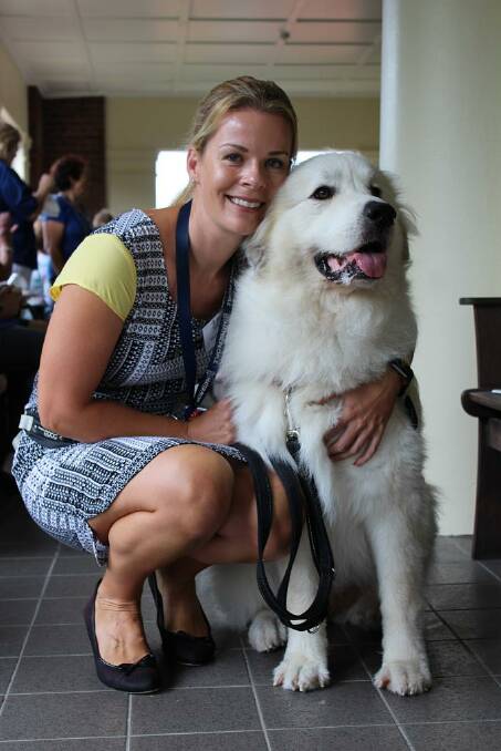 CUDDLES: Helen Squibb with therapy dog and internet sensation Belle. Photo: Supplied