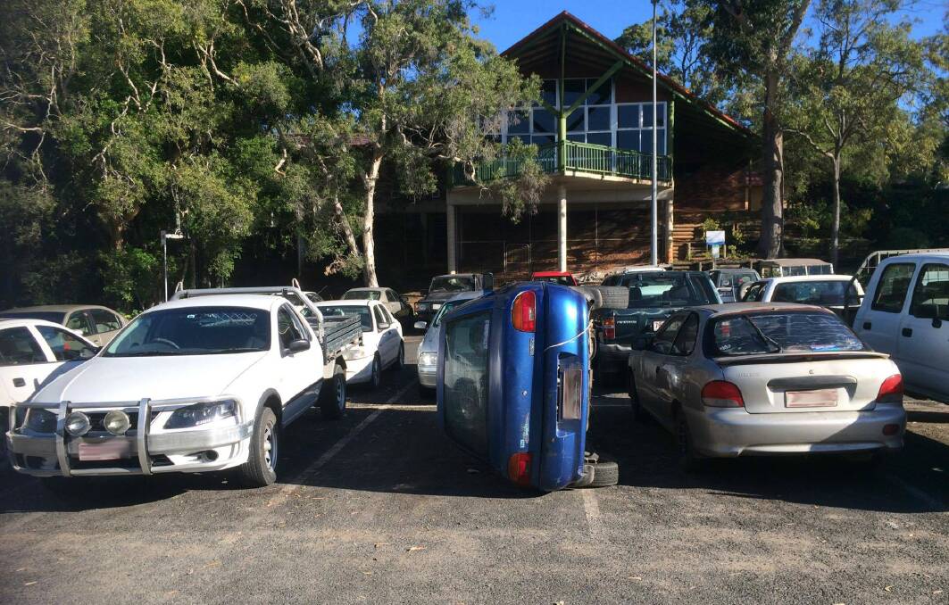 TIPPED: The car pushed on its side in the Russell Island ferry car park. Photo: Vivien Fleming