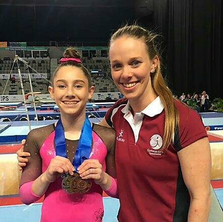 MEDAL WINNER: Victoria Point YMCA gymnast Jayde Beutel with coach Kellie Trask. Photo: Supplied