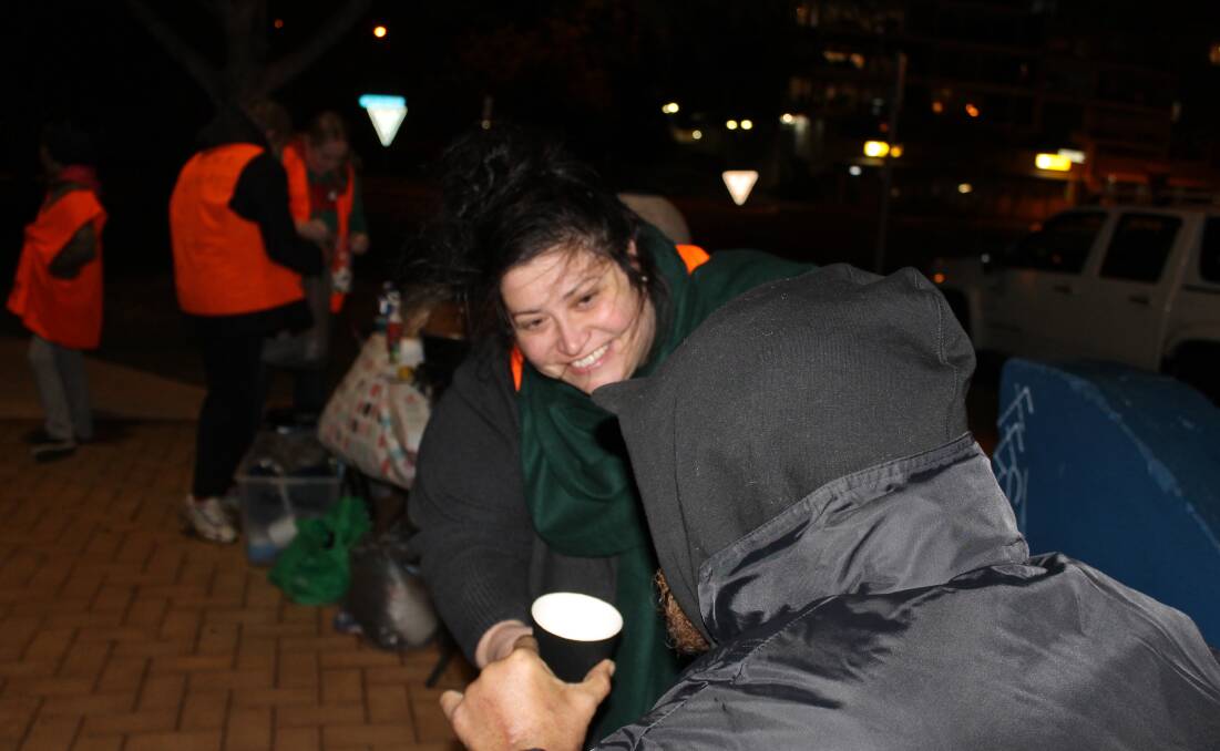 HELPING THE HOMELESS: Night Ninjas founder Alix Russo gives a cup of warm soup to a man who was homeless and had both legs amputated. Photo: Cheryl Goodenough
