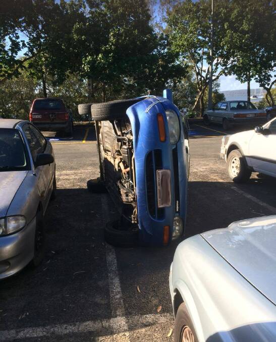 TIPPED: The car pushed on its side in the Russell Island ferry car park. Photo: Vivien Fleming