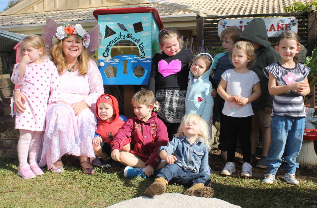 SURROUNDED: Lorraine Halse is surrounded by children during the opening of the street library outside her house in Sylvia Court, Capalaba. Photo: Cheryl Goodenough
