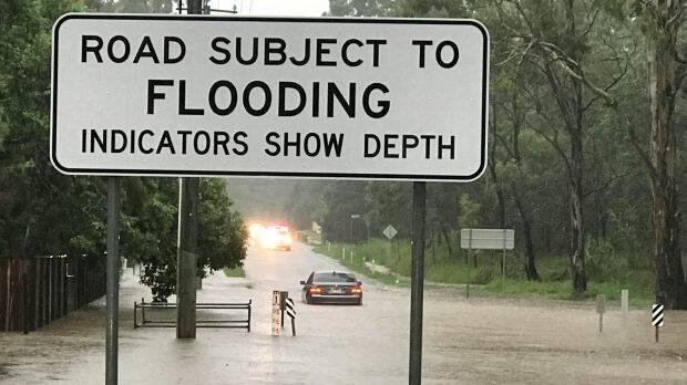 A car caught in flooding on Jones Road, Bellbird Park west of Brisbane. Photo: Paul Tully