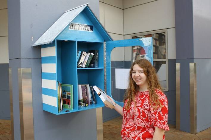 BOOKWORM: Capalaba's Bonnie Williams exchanges a book at the Little Free Library. Photo: Supplied