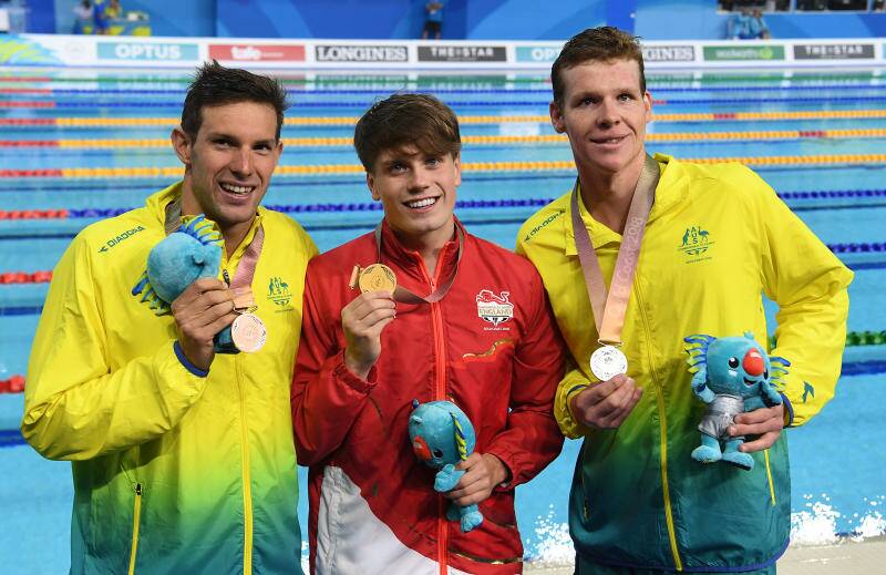 CHAMPIONS: Daniel Fox (left) and Liam Schluter (right) pose for photographs after winning silver and bronze medals in the mens S14 200m freestyle final on day one of swimming competition at the XXI Commonwealth Games at Gold Coast Aquatic Centre. Photo: Dave Hunt