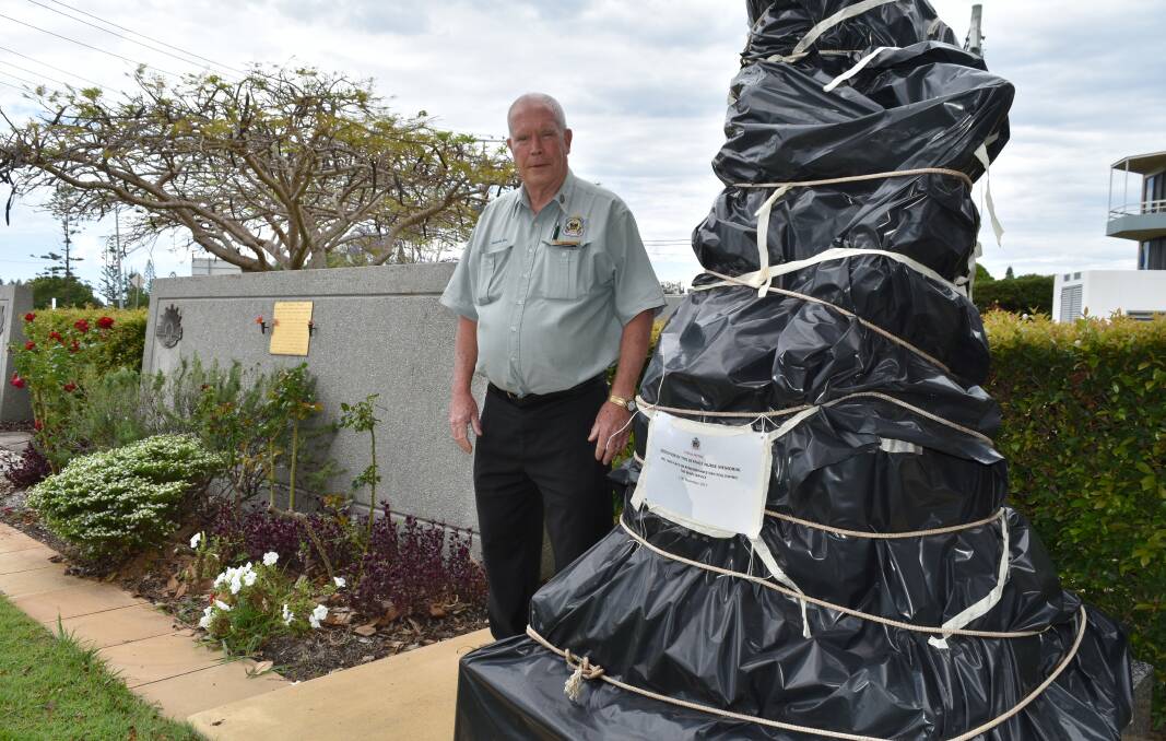 UNDER WRAPS: Redlands RSL Sub Branch president Alan Harcourt stands next to the wrapped nurse and wounded Digger statue at Cleveland's Anzac memorial park. Photo: Hannah Baker