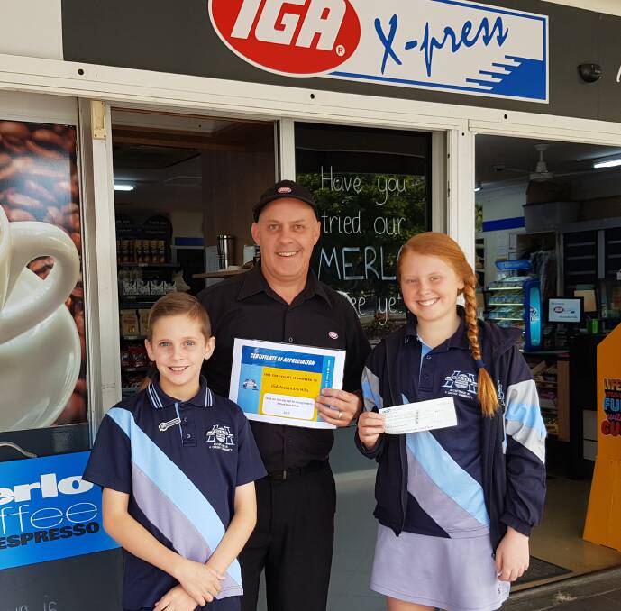 SUPPORT: Collecting a cheque from IGA are Hilliards State School captain Zac Clow and vice captain Tiana O'Toole with  IGA X-press Alexandra Hills Dan Rigney