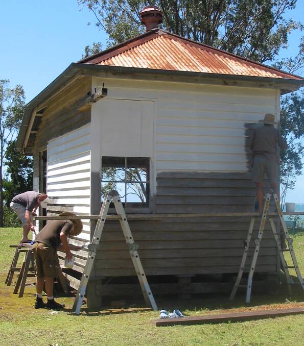 RESTORATION: Men work on restoring a male patient's hut at Peel Island.