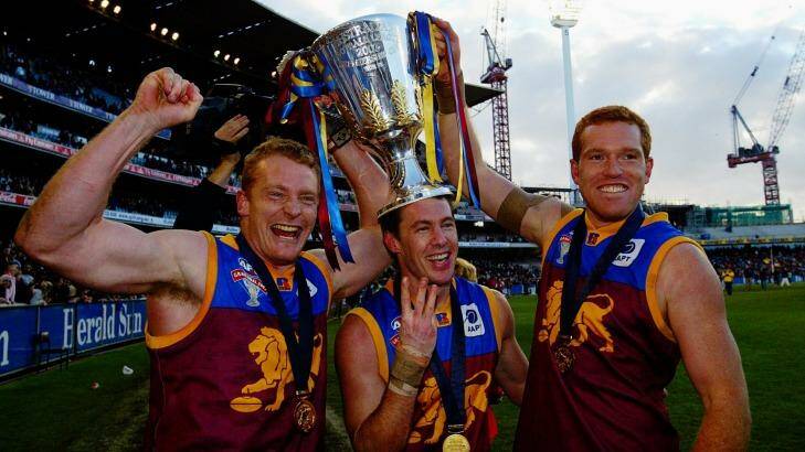 Three of the best: Michael Voss, Craig McCrae and Justin Leppitsch with the AFL premiership cup in 2003. Photo: Ray Kennedy