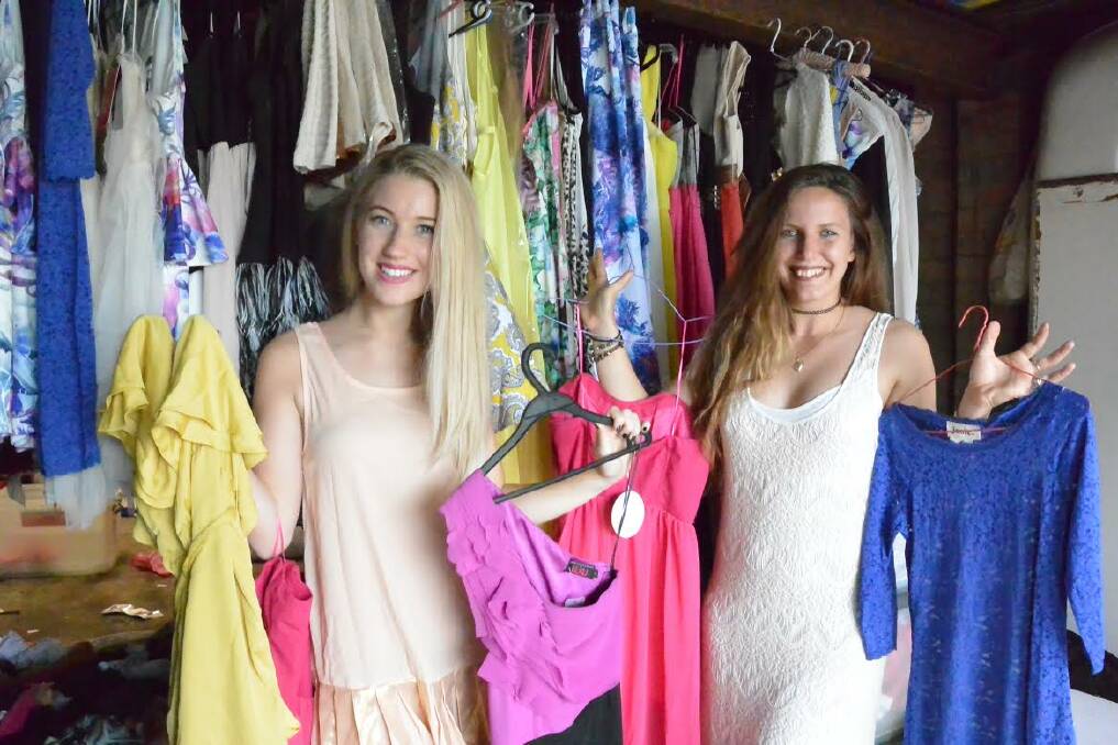 Jess Maher and Sarah Sammut show off some of the clothes available at Saturday's yard sale in Cleveland.