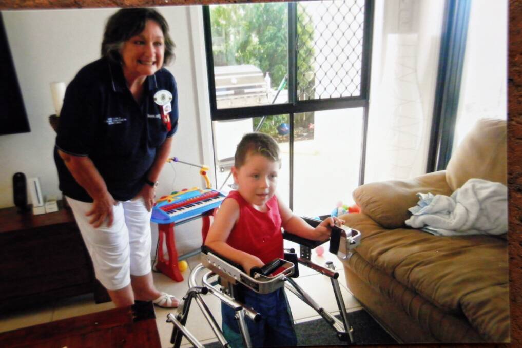 Lions club president Pauline Denisenko watches young Redland Bay resident Matthew as he tries out the new Kaye Mobility walker the club recently presented to him.