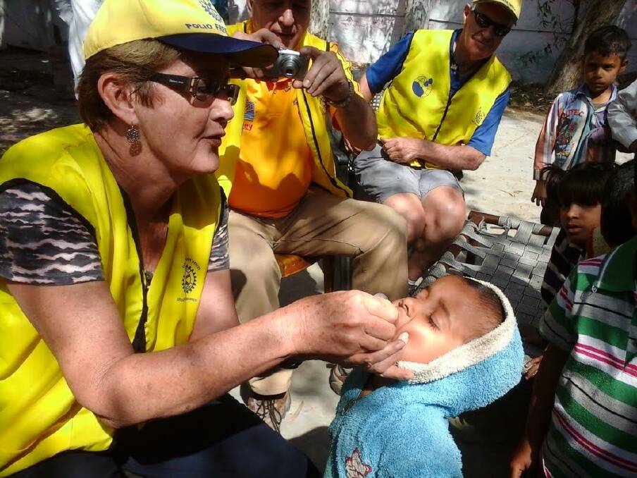 Capalaba Rotary Club member Beryl Sutcliffe administers polio drops as part of 2015 National Immunisation Day in India.