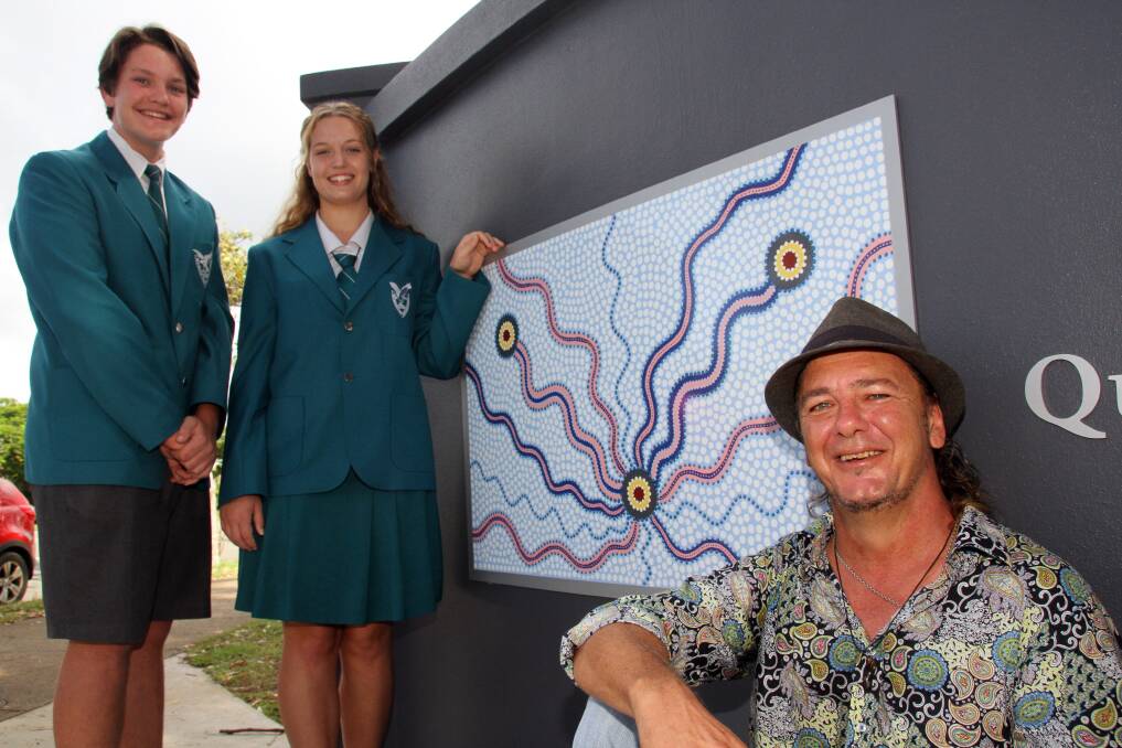 Craig Tapp of North Stradbroke Island with his mural outside Wellington Point State High School and school captains Matthew Wilson and Olivia Williams. 
Photo by Chris McCormack