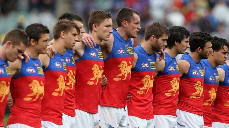Lions players line up for a moments silence to pay respect for murdered Adelaide Crows coach Phil Walsh. Photo: Paul Kane