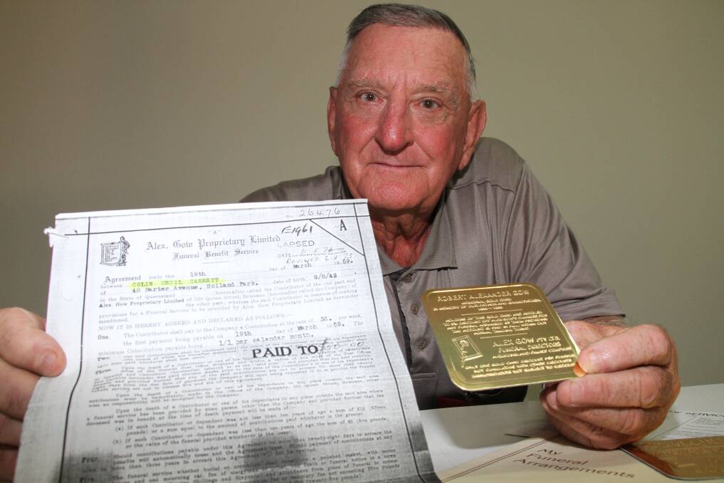 Colin Carrett of North Stradbroke Island with one of the two tokens entitling him to 5 percent off the cost of a funeral which Alex Gow Funerals gave him after cancelling the policy he had paid for in 1959.Photo by Chris McCormack