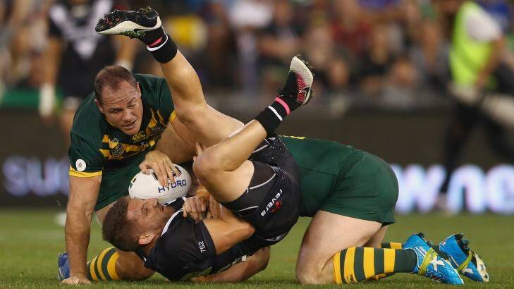 Upside down: Kiwis hooker Lewis Brown is tackled by the Kangaroos. Photo: Mark Kolbe