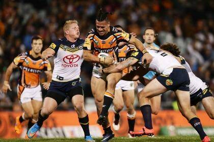 Tight contest: Sauaso Sue of the Wests Tigers tries to burst through the North Queensland defence.