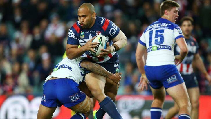 Wrapped up: Roosters forward Sam Moa takes on the defence. Photo: Matt King