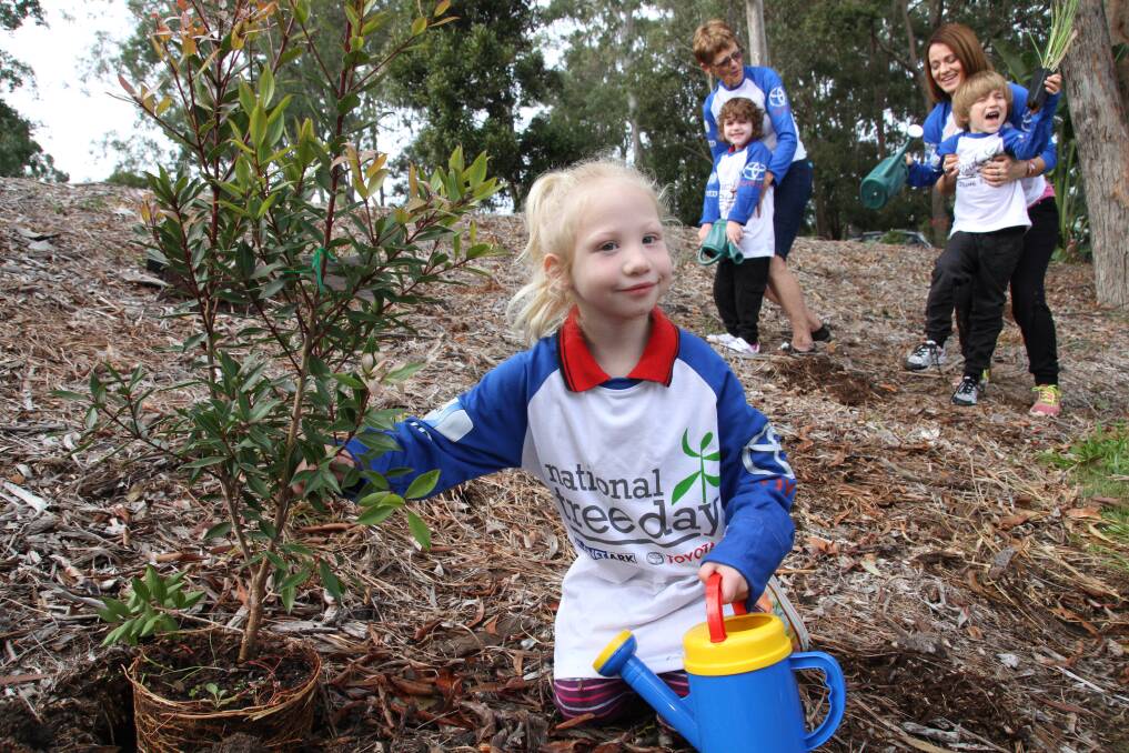 Redlands Special School prep students Sahara Wedd, Tiffany Tognola and Riley Howlett, all 5, help plant trees at school on Schools National Tree Day with volunteer gardener Judy Viney and teacher aid Kaye Coleborn. Photo by Chris McCormack