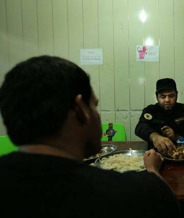 'We have a creed': Imam Ali Brigade fighters take their evening meal together. Photo: Kate Geraghty
