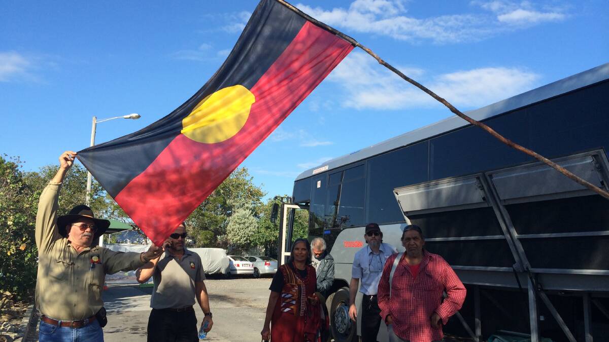 Quandamooka elders hold out the indigenous flag in June before lodging their High Court challenge against the extension of sand mining. PHOTO: Judith Kerr  