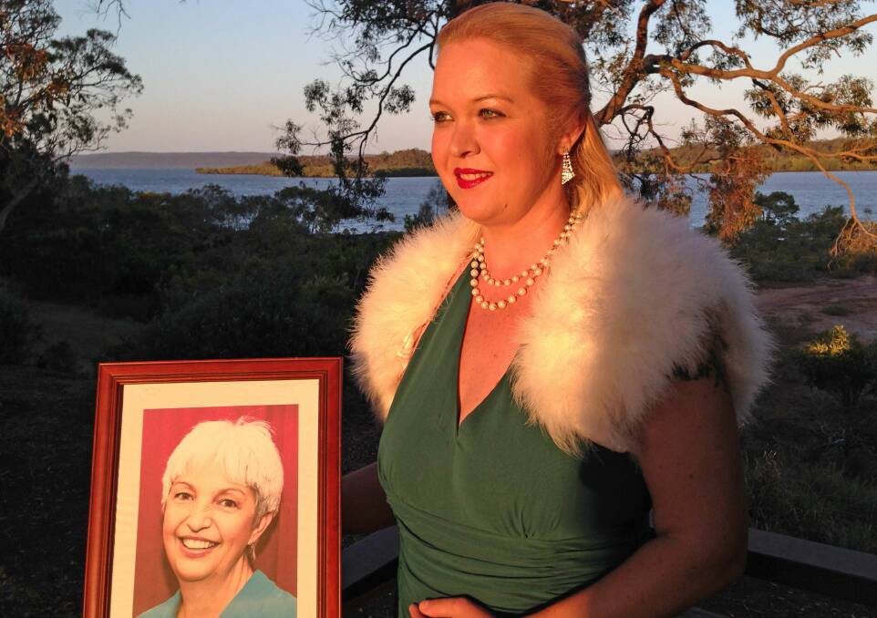 Macleay Island model Iona Marcon, with a photograph of her boss Debi Dingwell, who died after a battle with cancer. Iona will model some of the garments at the parade, which will raise money for breast cancer research.