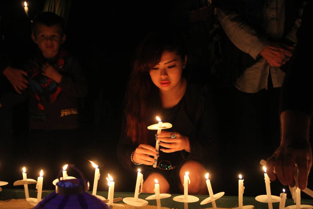 May 7 - Kirina Ayukawa of Alexandra Hills was among many to place a candle in remembrance at the candlelight vigil at Raby Bay harbour to honour those killed by domestic violence.
Photo by Chris McCormack