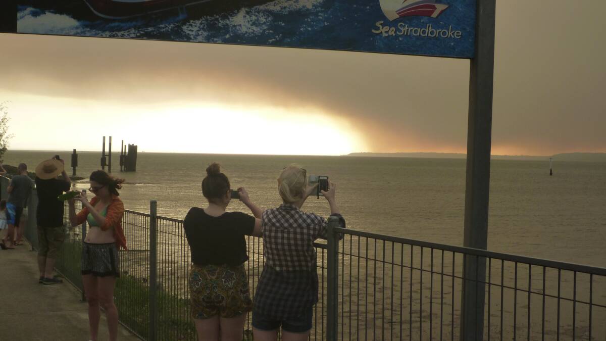 january 4 - People turn out at Toondah Harbour to witness the smoke haze from the North Stradbroke Island bushfires.
Photo by Stephen Jeffrey