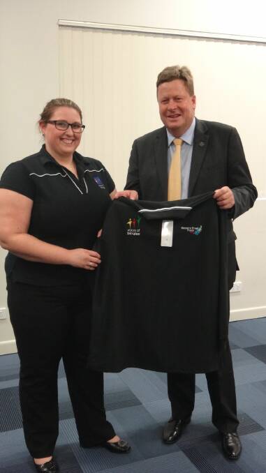 Natasha Calderbank, left, is presented by Senator Michael Ronaldson with her special Voices of Birralee uniform, which she will wear during Anzac Day performances in France.
