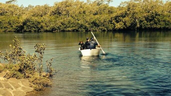 Police borrow a rowboat to cross Tingalpa Creek to search for an accused thief on Wednesday. Photo: Queensland Police Service.
